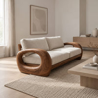 Sofa with thick open loop wooden arms and two seat cushions in a Scandinavian living room with white walls