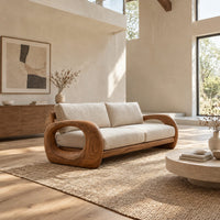 Sofa with thick open loop wooden arms and two seat cushions in a bright open plan living room
