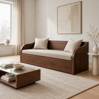 Wood sofa with sweeping arms and a deep paneled base in a Scandinavian living room with white walls
