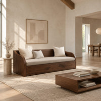 Wood sofa with sweeping arms and a deep paneled base in a bright open plan living room