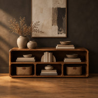 Open console table with soft edges and a long shelf above three cubbies in a dark studio against a charcoal plaster wall