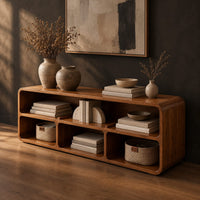 Open console table with soft edges and a long shelf above three cubbies, three-quarter view showing the grain