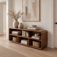 Open console table with soft edges and a long shelf above three cubbies in a Scandinavian entryway with white walls
