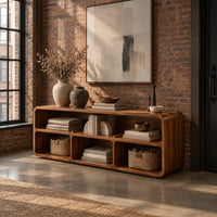 Open console table with soft edges and a long shelf above three cubbies in an industrial loft entryway with exposed brick