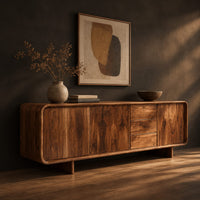 Long low sideboard with soft edges and a drawer stack between doors, three-quarter view showing the grain
