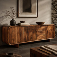 Corner detail of long low sideboard with soft edges and a drawer stack between doors beside wood, brass and linen samples