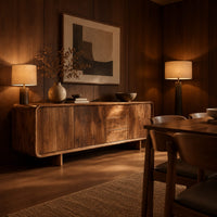 Long low sideboard with soft edges and a drawer stack between doors in an evening dining room with walnut wall paneling