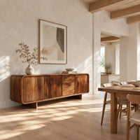 Long low sideboard with soft edges and a drawer stack between doors in a bright open plan dining room