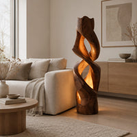 Floor lamp carved as a twisting solid column with glowing cutouts in a Scandinavian living room with white walls