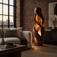 Floor lamp carved as a twisting solid column with glowing cutouts in an industrial loft living room with exposed brick