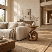 Round side table with a swirling stem and a coiled spiral base in a bright open plan living room