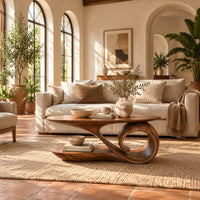 Oval coffee table with a top that sweeps into one large spiral curl in a bright living room with arched windows and plants