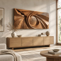 Wide wall art panel with a carved spiral circling a domed center above a light oak sideboard in daylight