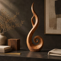 Corner detail of flame shaped sculpture with an open center and a spiral curl at the base beside wood, brass and linen samples