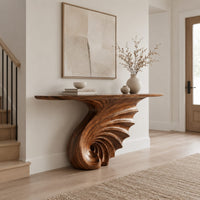 Console table on a single spiral scroll base with fanned carved ridges in a Scandinavian entryway with white walls