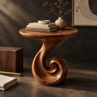 Corner detail of scroll base side table with a circular top and spiral foot beside wood, brass and linen samples