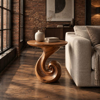 Scroll base side table with a circular top and spiral foot in an industrial loft living room with exposed brick