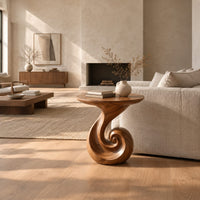 Scroll base side table with a circular top and spiral foot in a bright open plan living room