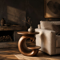 Spiral side table with a curled base and a small lower shelf in a dark living room at golden hour