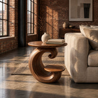 Spiral side table with a curled base and a small lower shelf in an industrial loft living room with exposed brick