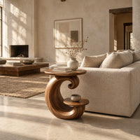 Spiral side table with a curled base and a small lower shelf in a bright open plan living room