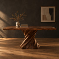 Long dining table on two spiral twisted pedestals with a thick flat top in a dark studio against a charcoal plaster wall