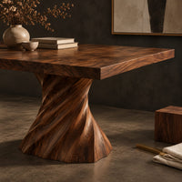 Corner detail of long dining table on two spiral twisted pedestals with a thick flat top beside wood, brass and linen samples