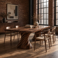 Long dining table on two spiral twisted pedestals with a thick flat top in an industrial loft dining room with exposed brick