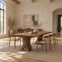 Long dining table on two spiral twisted pedestals with a thick flat top in a bright open plan dining room