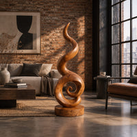 Spiral wood sculpture with a tall flame like swirl and a disc shaped base in an industrial loft living room with exposed brick