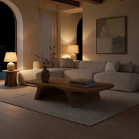 Pale splayed leg coffee table in an evening room lit by two lamps