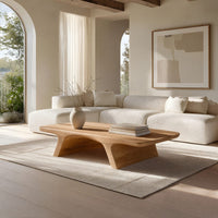 Pale splayed leg coffee table in a sunlit room with large windows and plants