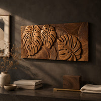 Detail of wood wall art with three carved split leaves in deep relief beside wood, brass and linen samples