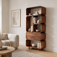 Tall stacked bookshelf of soft edged cubbies with a wide drawer in a Scandinavian living room with white walls