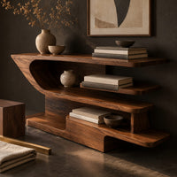 Corner detail of open shelf console table with staggered shelves on a stepped base beside wood, brass and linen samples