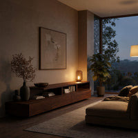 Low stepped riser TV console with drawers in an evening room lit by two lamps