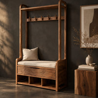 Corner detail of storage bench with coat pegs, a top shelf, a cushioned seat and open cubbies beside wood, brass and linen samples