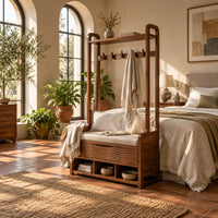 Storage bench with coat pegs, a top shelf, a cushioned seat and open cubbies in a bright bedroom with arched windows and plants
