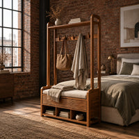 Storage bench with coat pegs, a top shelf, a cushioned seat and open cubbies in an industrial loft bedroom with exposed brick