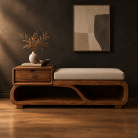 Wood bench with a small drawer and an open wave shaped base in a dark studio against a charcoal plaster wall