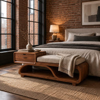 Wood bench with a small drawer and an open wave shaped base in an industrial loft bedroom with exposed brick
