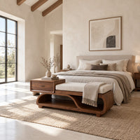 Wood bench with a small drawer and an open wave shaped base in a bright open plan bedroom