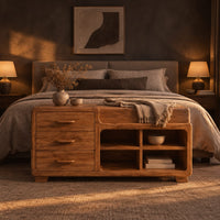 Low wooden bench with three drawers, four open cubbies and a cushioned seat in a dark bedroom at golden hour