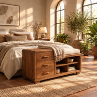 Low wooden bench with three drawers, four open cubbies and a cushioned seat in a bright bedroom with arched windows and plants