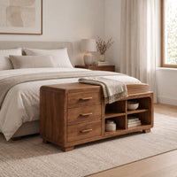 Low wooden bench with three drawers, four open cubbies and a cushioned seat in a Scandinavian bedroom with white walls