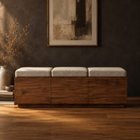 Low wooden bench with three seat cushions and a three panel front in a dark studio against a charcoal plaster wall