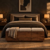 Low wooden bench with three seat cushions and a three panel front in a dark bedroom at golden hour