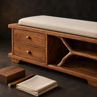 Corner detail of storage bench with two drawers and a branch shaped open shelf beside wood, brass and linen samples