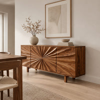 Sideboard with a sunburst carved center panel and short legs in a Scandinavian dining room with white walls