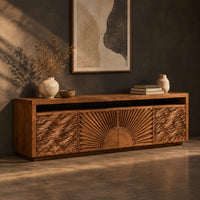 Tv stand with a carved sunburst center and wave relief side panels, three-quarter view showing the grain